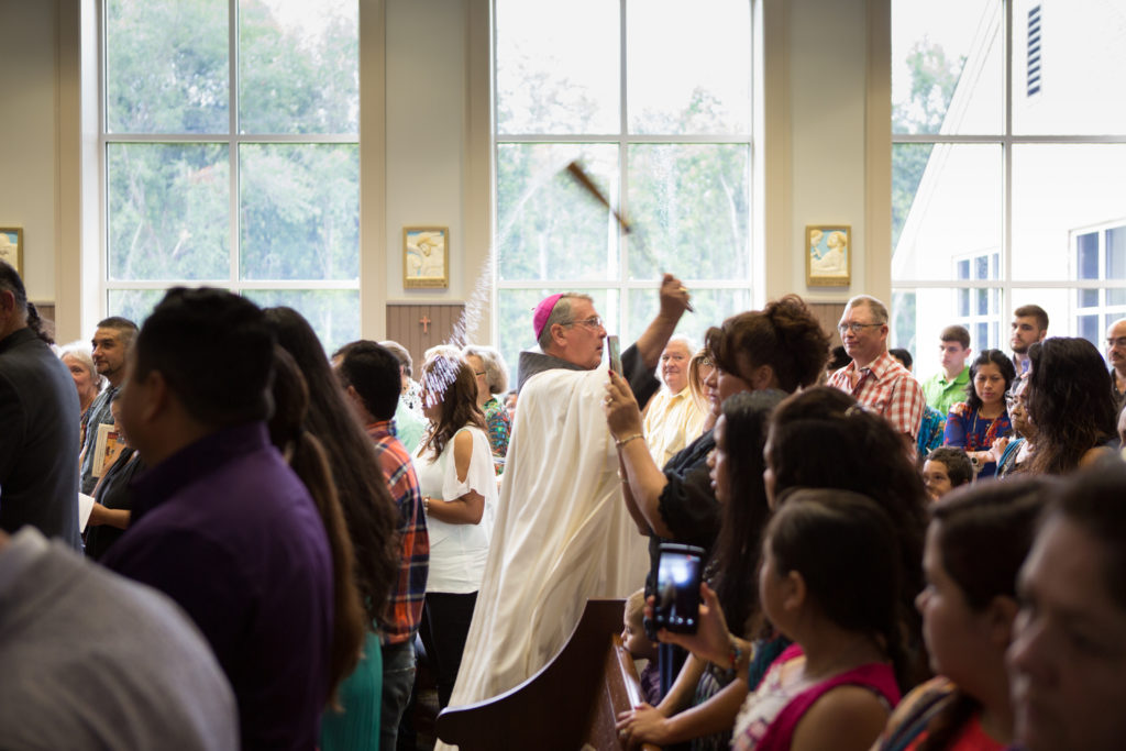 The Bishop blesses parishioners with holy water