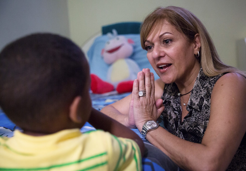 Melva Arbelo prays with a child in Puerto Rico