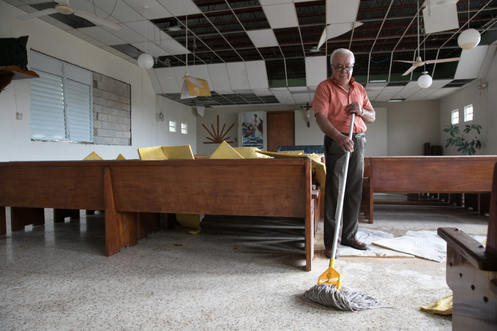 Man cleaning up a destroyed sanctuary after the hurricanes in Puerto Rico 