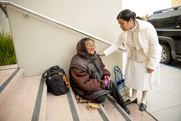 Catholics sister reaching out to a woman in need on the street