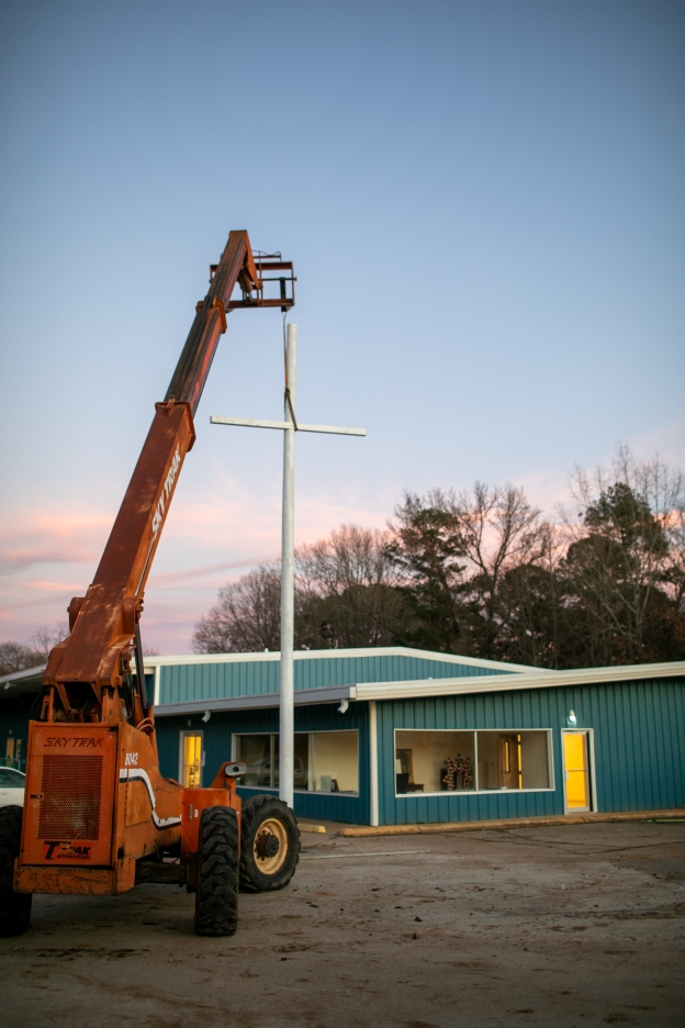 A Sky Track holds up a newly installed cross.