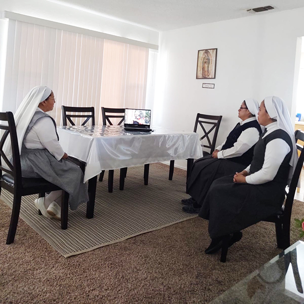 Catholic sisters watch Mass on a laptop 