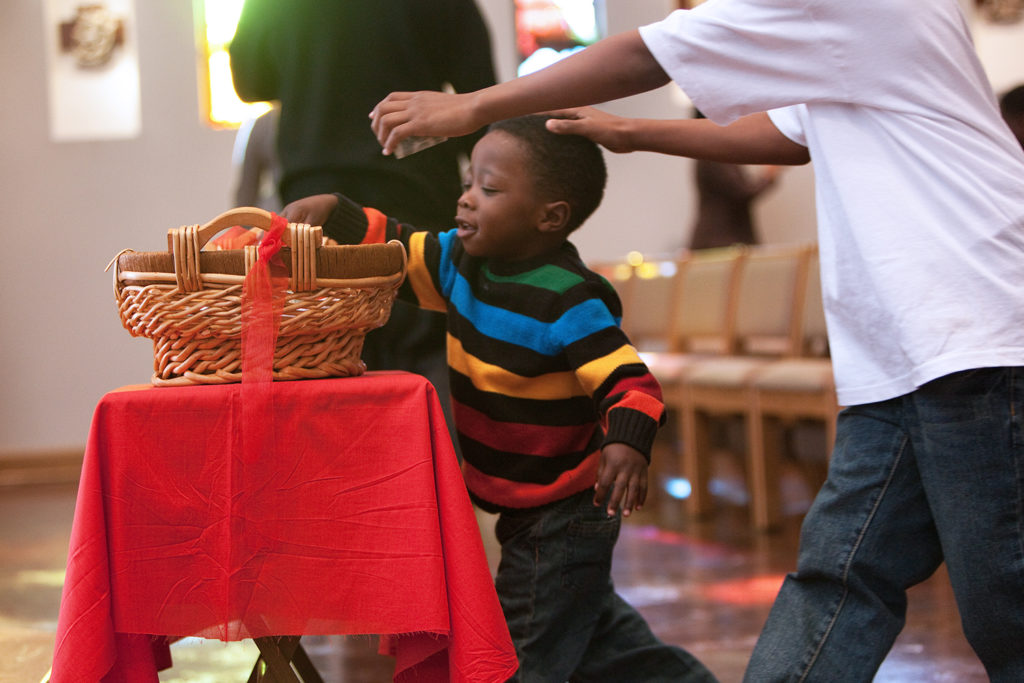 Boy puts money in the collection basket