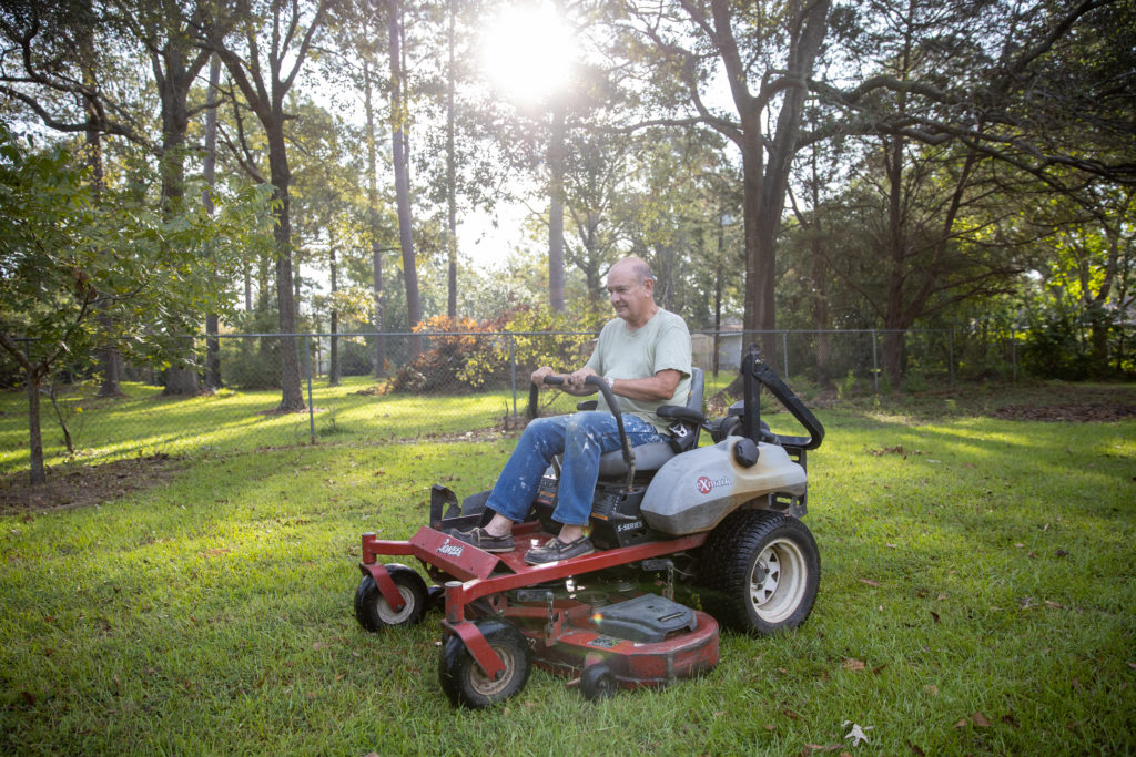 Father Foshage on a riding lawnmower